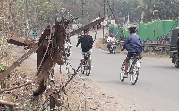 करनडीह बिजली ऑफिस गेट के बगल में सड़क किनारे झुका बिजली खंभा और निकला हुआ जानलेवा एंगल.